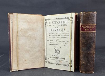 an old book sitting open on top of a table next to a book