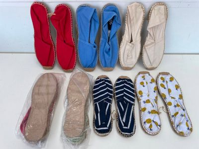 Plusieurs paires de pantoufles sont alignées en rangée