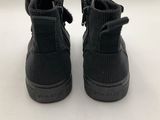 a pair of black sneakers on a white surface