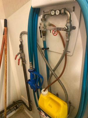 un réservoir d'eau et un tuyau accroché au mur