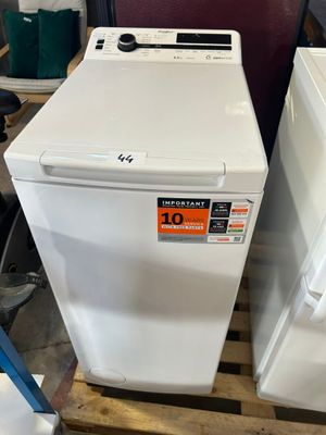 two white washers sitting on pallets in a room