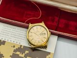 an image of a gold watch sitting in a red box on a table