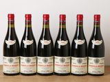 six bouteilles de vin rouge alignées sur une table en bois