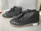 pair of black leather boots with studded laces on them