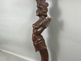 une vieille étagère en bois sur laquelle trône une statue