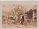 an old photo of a man standing in front of a shack