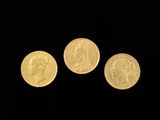 three gold coins are shown against a black background