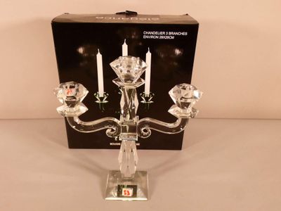 a glass candelab with three candles on it