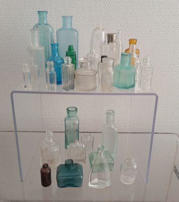 une étagère en verre sur laquelle sont posées diverses bouteilles
