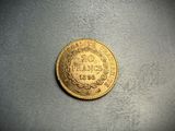 a close up of a gold coin on a gray surface