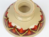a red and yellow vase sitting on a white surface