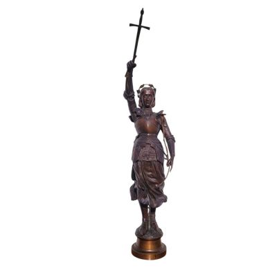 a bronze statue of a woman holding a cross and a sword