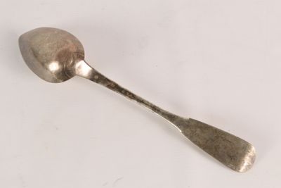 a spoon that is sitting on a white surface