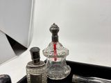 a bottle of perfume and a pair of scissors on a tray