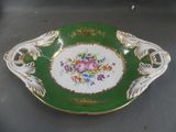 a green and white plate with a floral design on it