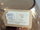 a glass vase with a tag on it sitting on a table