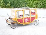 a small yellow and red carriage on the street