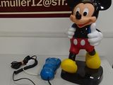 une figurine de Mickey Mouse posée à côté d'un plat de service sur une table