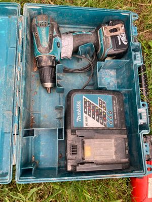 une boîte à outils bleue contenant des outils, posée sur l'herbe