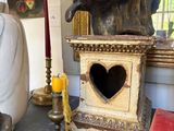 a statue of a man holding a heart on a table