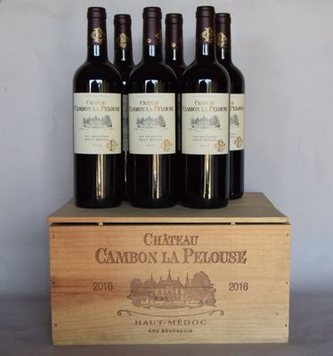 six bouteilles de vin se trouvent dans une caisse en bois posée sur une table