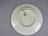 a white plate with a blue flower on it