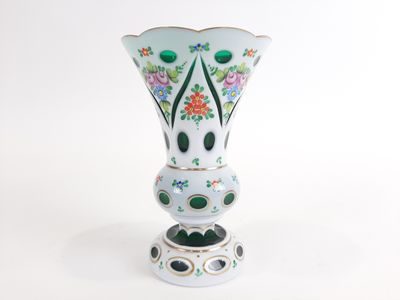 un vase blanc orné de fleurs vertes et roses