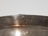 a large metal bowl with a handle on a table