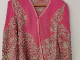 un cardigan rose suspendu à un cintre