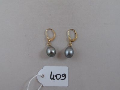 deux paires de boucles d'oreilles et une étiquette de prix posées sur une table