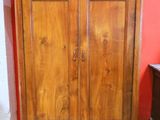 a wooden armoire in the corner of a room