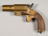 a brass revolver with a wooden handle on a white surface
