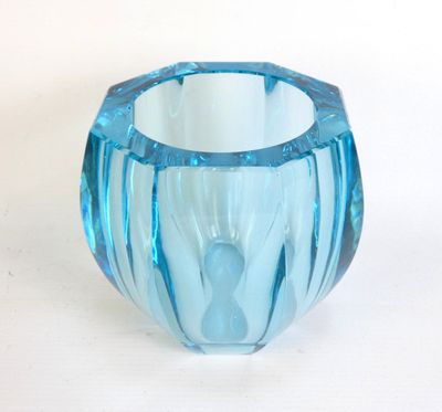 a blue glass vase sitting on a white surface