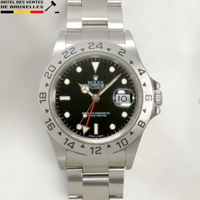 a rolex watch with a black dial and red second hand
