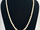un collier de perles blanches sur un mannequin noir