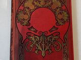 an old red book sitting on top of a white table