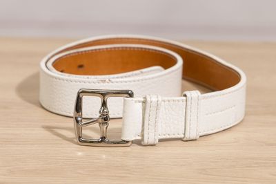 a close up of a white belt on a wooden surface