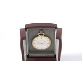 a small clock that is in a box on a white surface