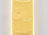 a close up of a gold bar on a white surface