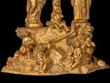 a gold statue of a man and a woman on a rock