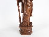 statue of a man holding a staff and a book