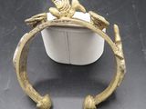 un gros plan d'un bracelet en or orné d'un oiseau