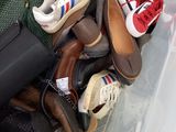 many pairs of shoes and bags in a bin