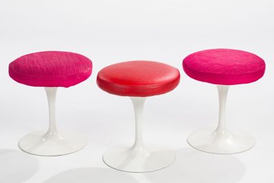 three red and white stools sitting next to each other on a white surface