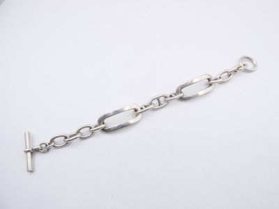 a close up of a silver chain bracelet on a white surface