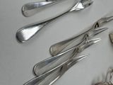 many spoons and forks laid out on the table