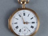 a gold pocket watch with roman numerals on it
