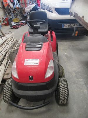 une tondeuse à gazon rouge garée dans un garage