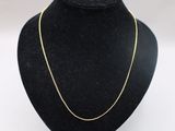 a gold chain necklace on a mannequin neck
