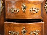 a small wooden chest of drawers with gold decorations